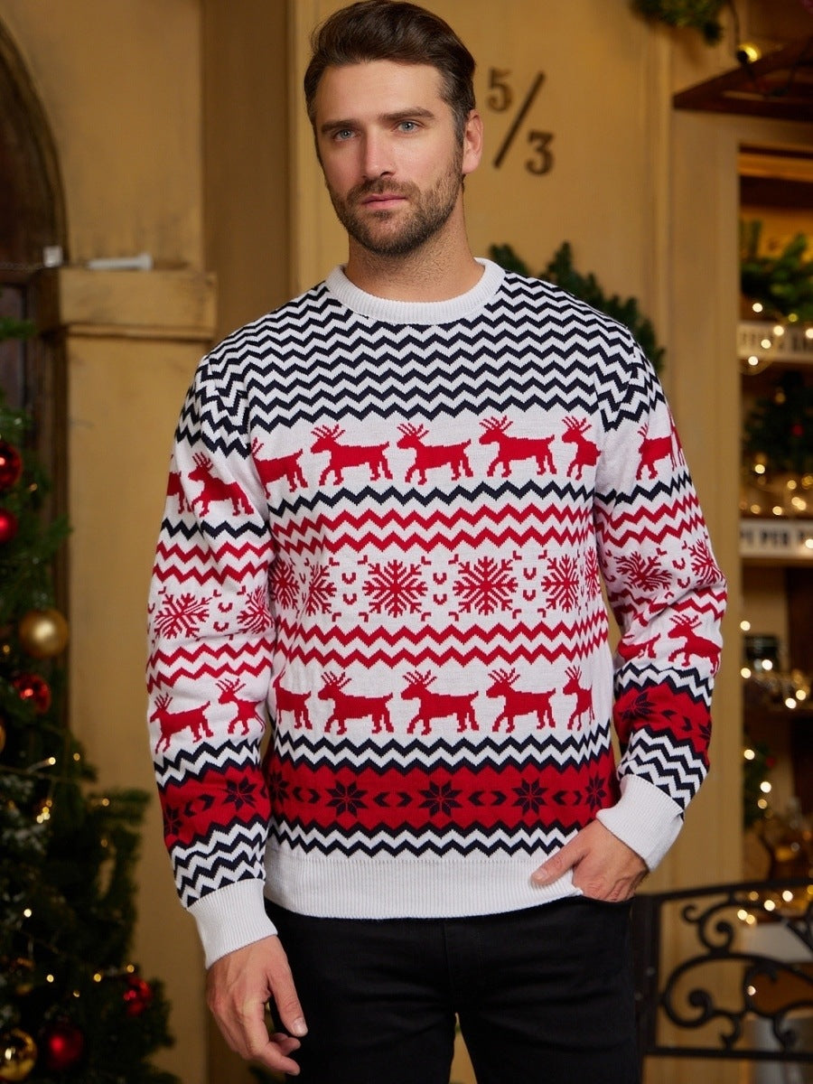 Man wearing a festive sweater with reindeer and snowflake pattern in a decorated room.