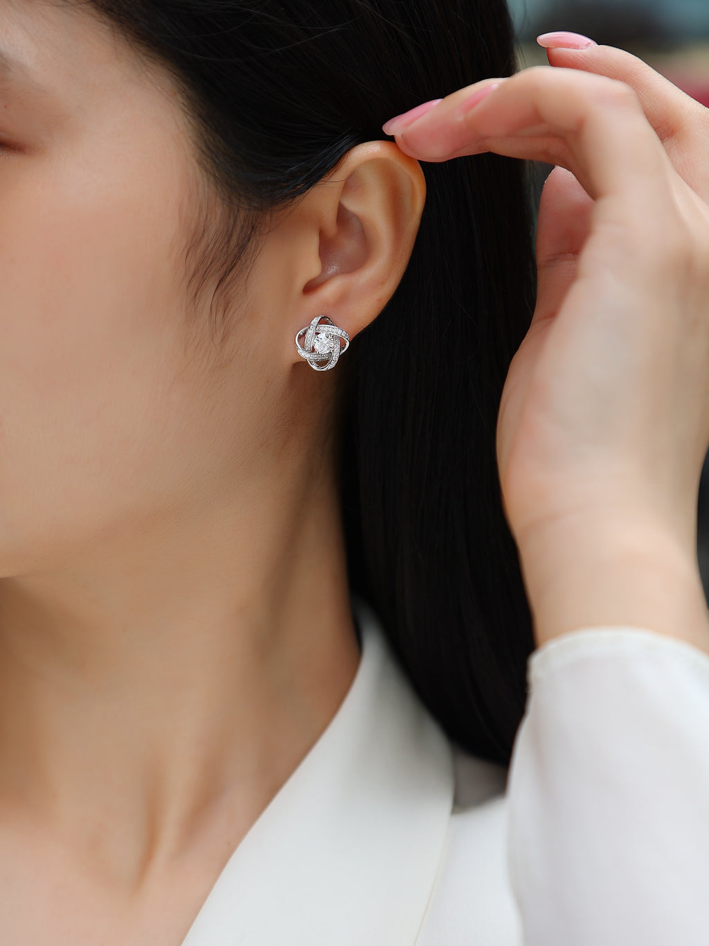 Close-up of a person wearing a floral earring with a blurred background