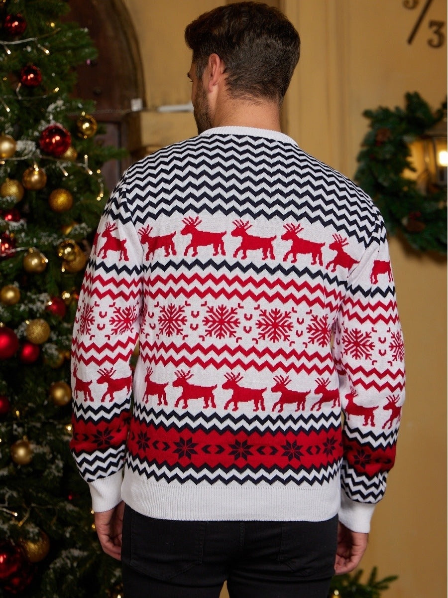 Person wearing a festive sweater with reindeer and snowflake patterns in front of a decorated Christmas tree.