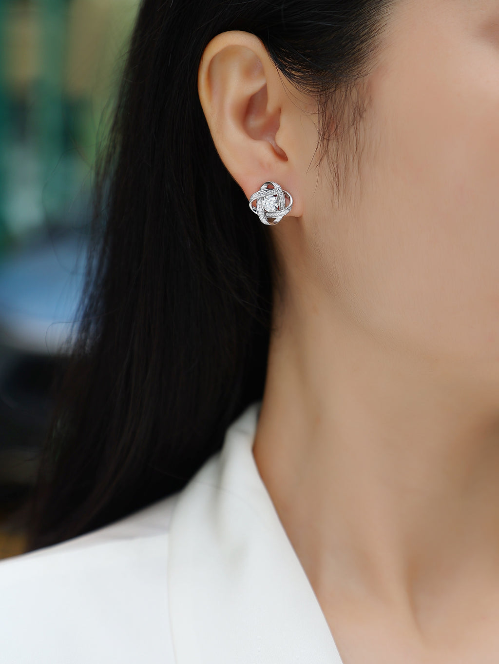 Close-up of a person wearing a silver floral earring.