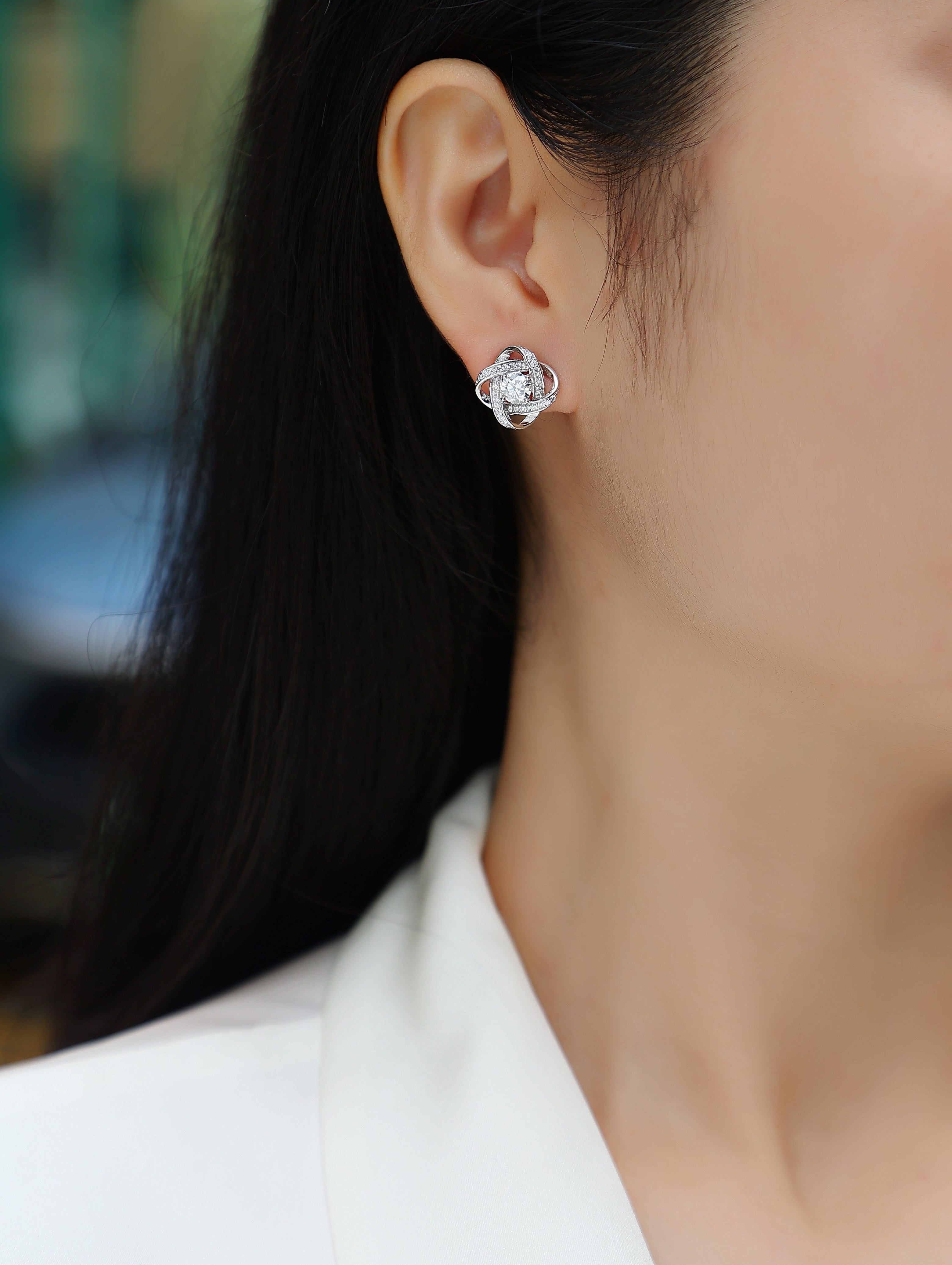 Close-up of a person wearing a silver floral earring.