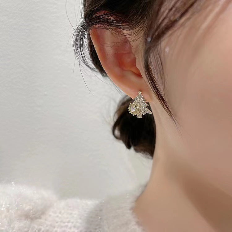 Close-up of a person wearing a delicate silver earring on a soft white background