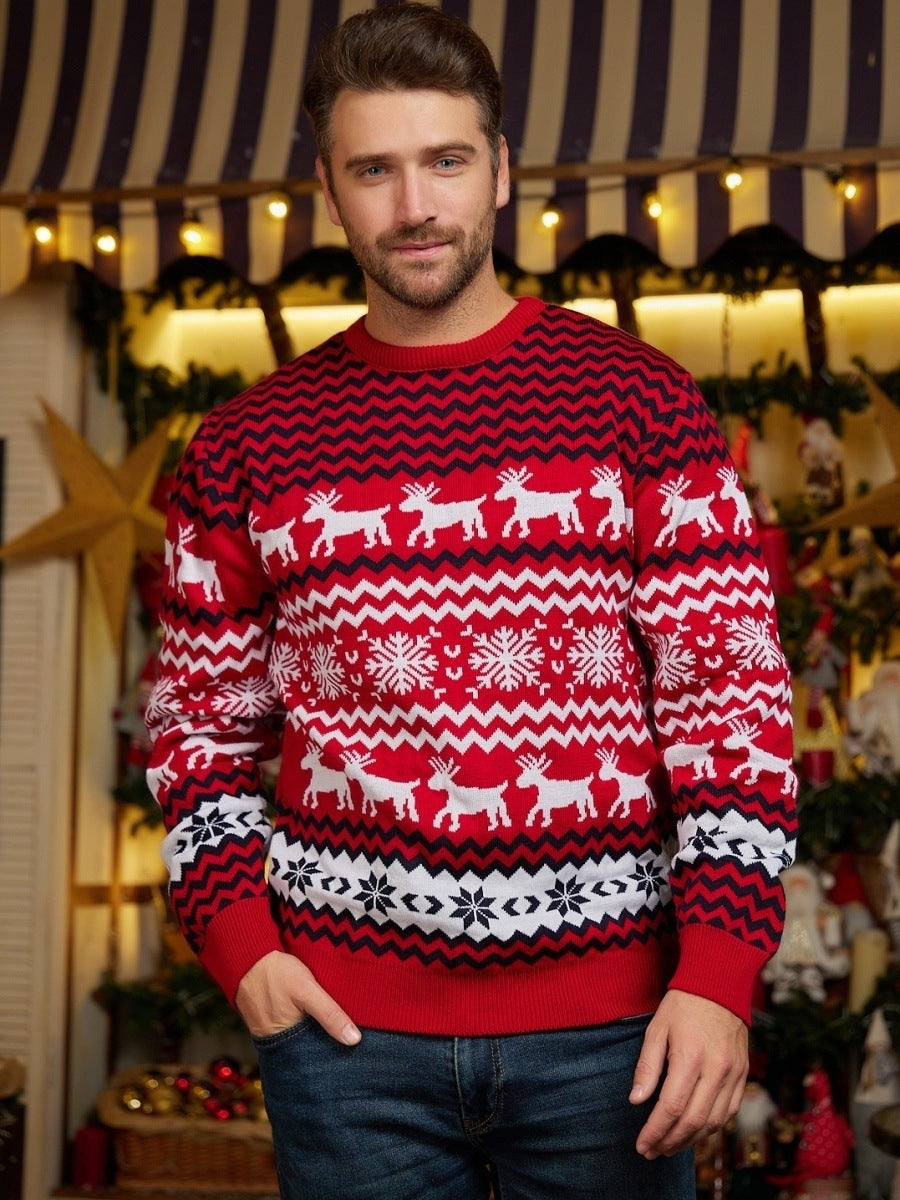 Man wearing a red Christmas sweater with reindeer and snowflake patterns in a festive setting.